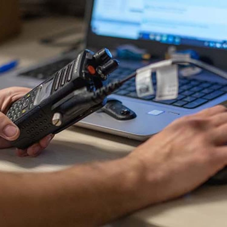 Technician servicing a commercial handheld two-way radio