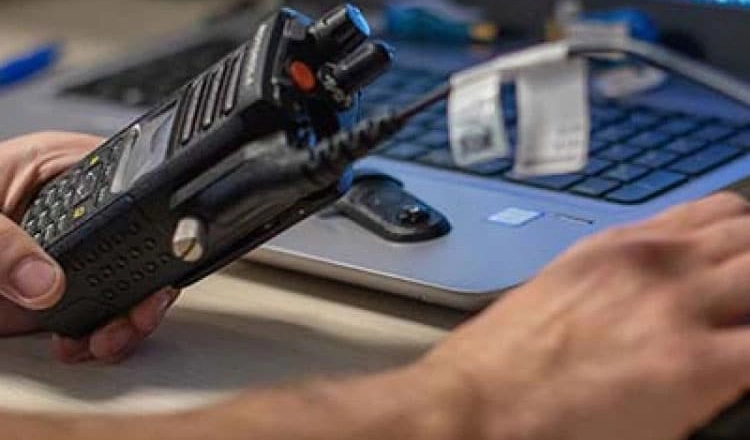 Technician servicing a commercial handheld two-way radio